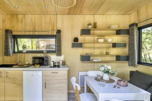 a kitchen and dining room of a tiny house at Slow Village Saint-Cybranet - Périgord in Saint-Cybranet