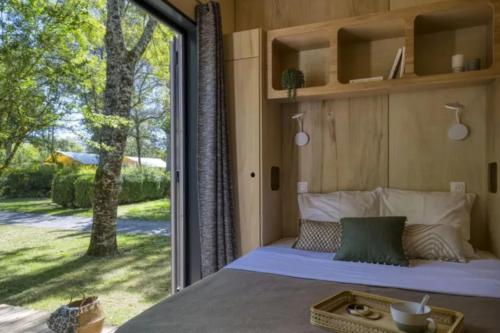 a bedroom with a bed and a large window at Slow Village Saint-Cybranet - Périgord in Saint-Cybranet