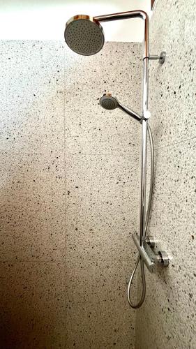 a shower with a shower head on a wall at Acero Rosso in Fontane