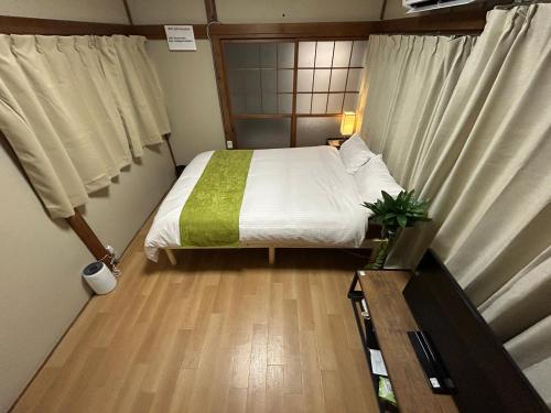 una piccola camera da letto con un letto e una finestra di Villa FUNABASHI a Funabashi