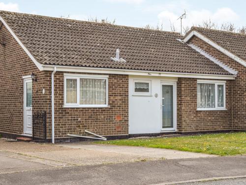 a brick house with a white door at Jenny's in Stalham