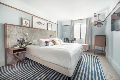 a bedroom with a large white bed and a desk at Villa Arthus-Bertrand in Noirmoutier-en-l'lle