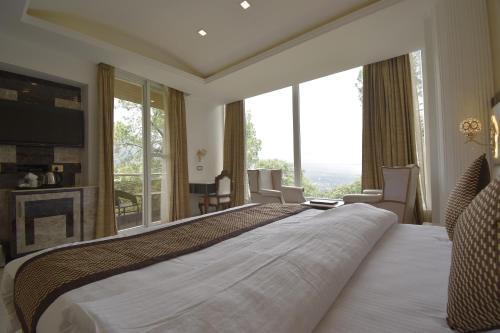 Postel nebo postele na pokoji v ubytování The Four Season Dharamshala # Centrally Heated & Air Cooled # Scenic Mountain View # Big Parking # Near Market # Top Rated # Most Awarded # Premium Rooms # Bar # Terrace # Lift # Property Of The Year##BY ROYAL CASTLE DHARAMSHALA#