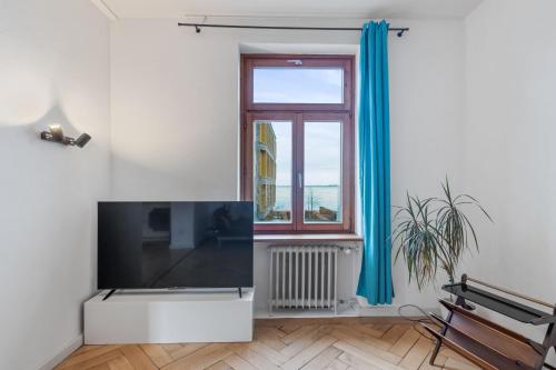 a living room with a large tv and a window at Villa Seeblick 1908 in Bregenz