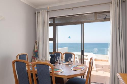 a dining room with a table and chairs with a view of the ocean at Chaka Terraces 10 in Ballito