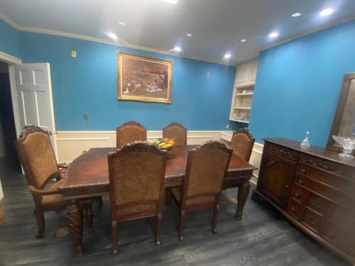 a dining room with a wooden table and chairs at Best value 3 Huge Bedrooms-Multiple parkings in Willmar