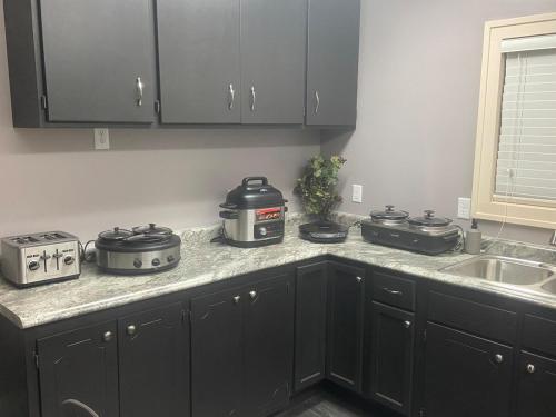 a kitchen with black cabinets and a counter top with appliances at Best value 3 Huge Bedrooms-Multiple parkings in Willmar