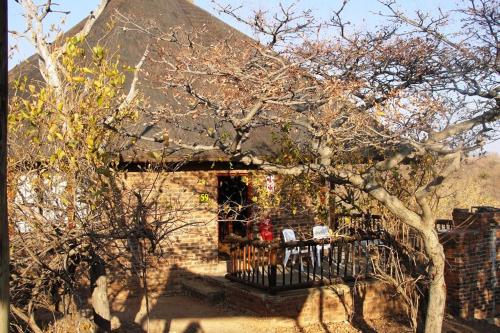Una casa con una mesa y sillas delante de ella. en Mabula Game Reserve, en Welbekend