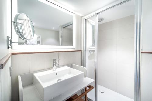 a white bathroom with a sink and a mirror at Villa Arthus-Bertrand in Noirmoutier-en-l'lle