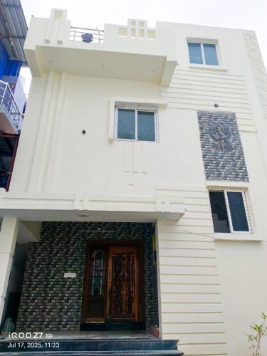 a white house with a wooden door and stairs at Rudra - 2 BHK Appartments - near Rameswaram Temple in Rāmeswaram
