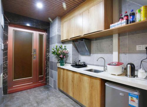 a small kitchen with a sink and a door at Guangzhou He She Art Apartment in Guangzhou