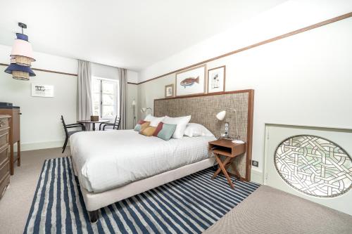 a bedroom with a bed with a blue and white rug at Villa Arthus-Bertrand in Noirmoutier-en-l'lle