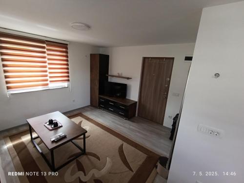 a living room with a coffee table and a television at Apartmani Kula in Tuzla