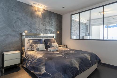 une chambre avec un grand lit et une grande fenêtre dans l'établissement Spacious apartment with sea view in Antibes, à Antibes