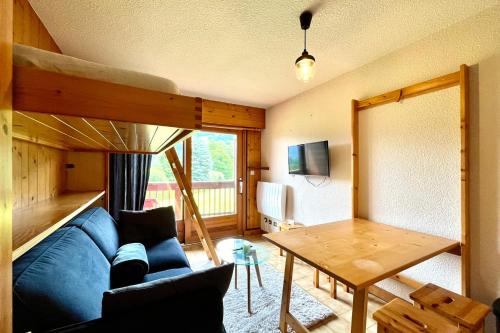 un salon avec un canapé bleu et une table dans l'établissement Studio with balcony close to the slopes, à Combloux