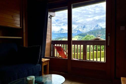 Cette chambre dispose d'une fenêtre offrant une vue sur les montagnes. dans l'établissement Studio with balcony close to the slopes, à Combloux