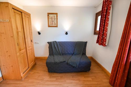 une chambre avec une chaise bleue dans l'angle d'une pièce dans l'établissement Beautiful Apt With Balcony At Combloux !, à Combloux