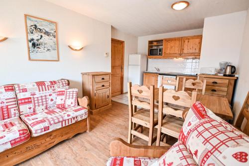 un salon avec un canapé et une cuisine dans l'établissement Flat In Residence With Swimming Pool, à Saint-Gervais-les-Bains