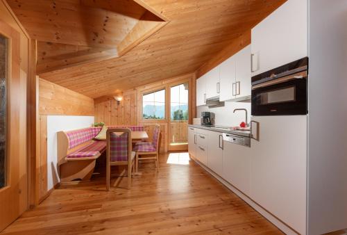 a kitchen with wooden ceilings and a table with chairs at Wellnesshaus Reichelt in Radstadt