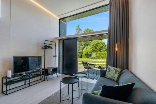 a living room with a couch and a tv at KODA LOFT - Urlaub im Tiny House Bodensee in Lauterach