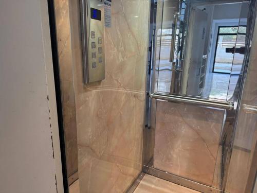 a shower with a glass door in a room at Loutraki, Poseidonos seaside Apartments in Loutraki
