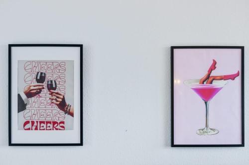 three framed pictures of a cocktail and a wine glass at Villa Seeblick 1908 in Bregenz