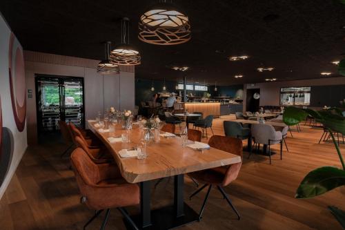 a dining room with a long table and chairs at Aarau West Swiss Quality Hotel in Oberentfelden