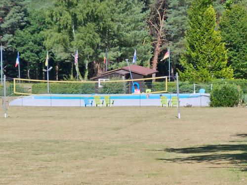 a swimming pool with chairs and flags in a field at Le calme in Braize