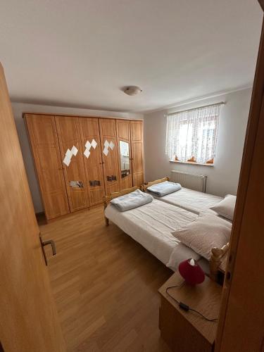 a bedroom with two beds and wooden cabinets at Apartmani Ruza in Krasno Polje
