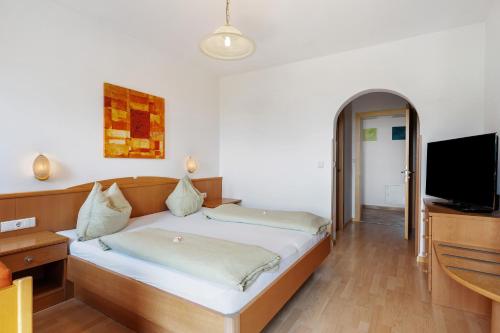 a bedroom with a bed and a flat screen tv at Seaberhof Kaltern in Caldaro