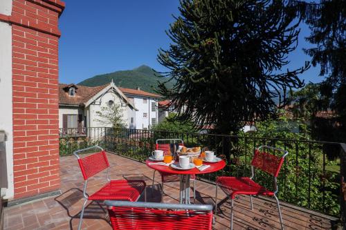 a red table and chairs on a patio at Villa Spa Dalia in Cannobio