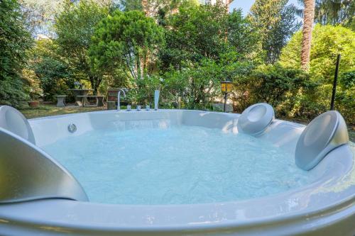 a large hot tub in a yard with trees at Villa Spa Dalia in Cannobio
