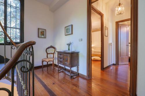 a hallway with a staircase and a chair and a mirror at Villa Spa Dalia in Cannobio
