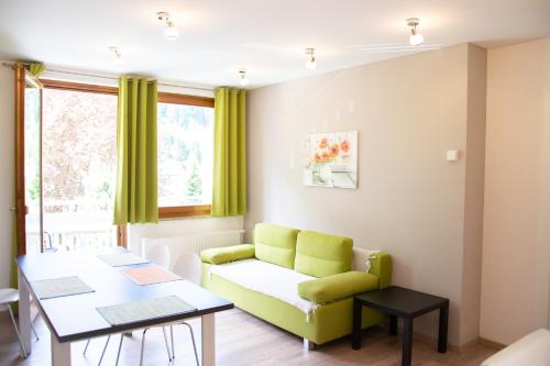 a living room with a green couch and a table at Ferienwohnung Klamberghof in Feld am See