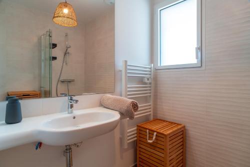 a bathroom with a sink and a mirror and a window at Maison HG - Presqu'ile de Crozon in Plomodiern