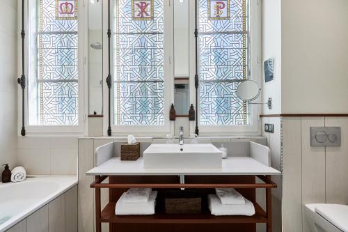 a bathroom with a sink and two stained glass windows at Villa Arthus-Bertrand in Noirmoutier-en-l'lle