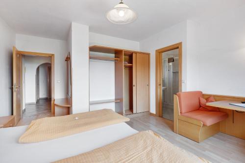 a bedroom with a bed and a desk and a chair at Seaberhof Kaltern in Caldaro