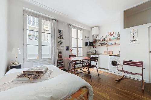 une chambre avec un lit, une table et des chaises dans l'établissement Cosy studio just a stone's throw from Montmartre, à Paris
