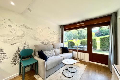 un soggiorno con divano e murale di montagna di Cosy 30m in the heart of Combloux a Combloux
