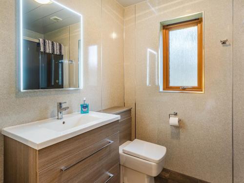 a bathroom with a sink and a toilet and a mirror at Balnagowan Mill in Nethy Bridge