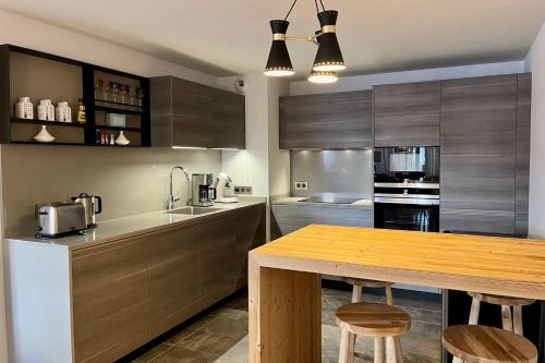 une cuisine avec des armoires en bois et une table en bois dans l'établissement Modern Apt At The Foot Of The Slopes In Megève, à Megève