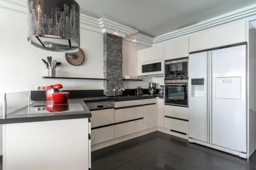 une cuisine avec des armoires blanches et un réfrigérateur blanc dans l'établissement Spacious apartment with sea view in Antibes, à Antibes