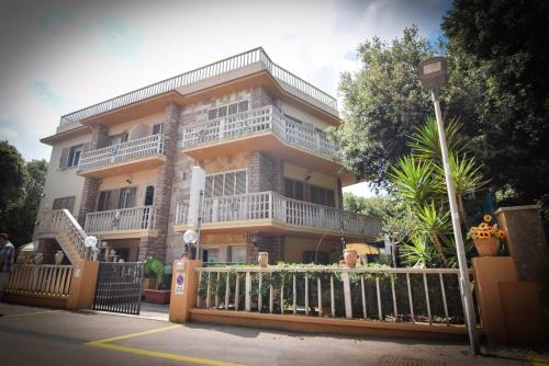 a large building with a fence in front of it at Hotel Villa Denia in San Vincenzo