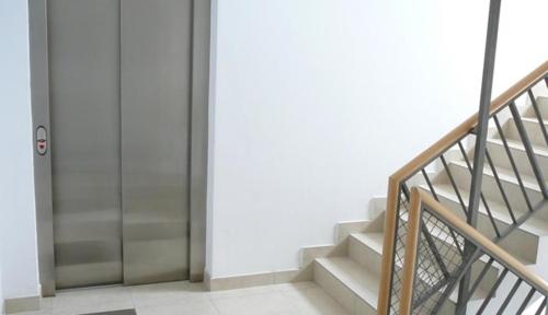 a staircase in a building with a metal elevator at Belle Apartments-Elegance Apartments in Belgrade