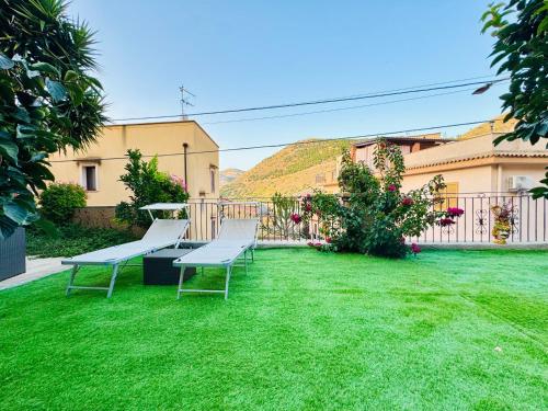 a yard with two benches on the grass at Nonna Sasà in Torretta