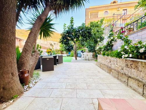 a walkway with trees and tables and a building at Nonna Sasà in Torretta