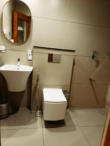 a bathroom with a toilet and a sink at Hotel KPM Tripenta in Palakkad