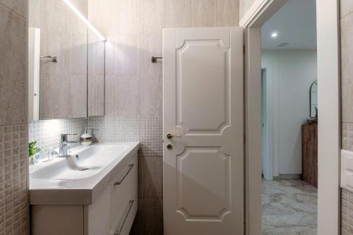 a white bathroom with a sink and a mirror at Morcote Romance by Quokka 360 - flat with patio and communal pool in Morcote
