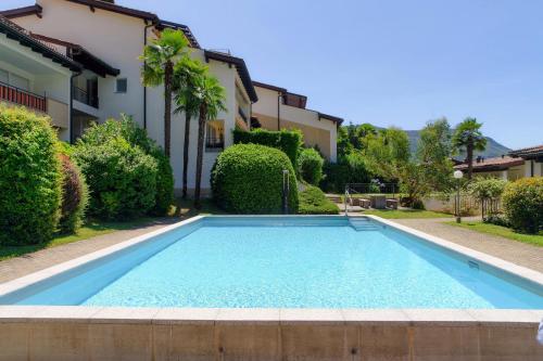 a swimming pool in front of a house at Morcote Romance by Quokka 360 - flat with patio and communal pool in Morcote