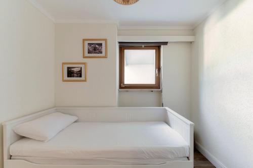 a small room with a bed and a window at Morcote Romance by Quokka 360 - flat with patio and communal pool in Morcote